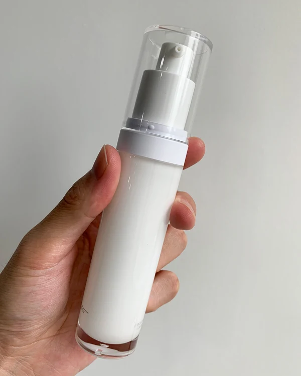 holding a PETG lotion bottle with a clear cap
