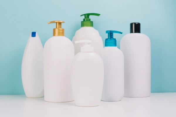 multiple white plastic cosmetic lotion bottles for different applications